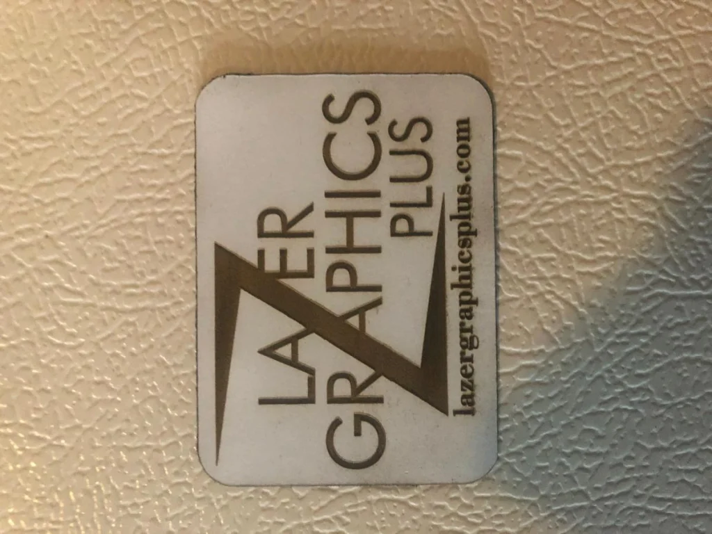Lazer Graphics Plus logo on textured surface.