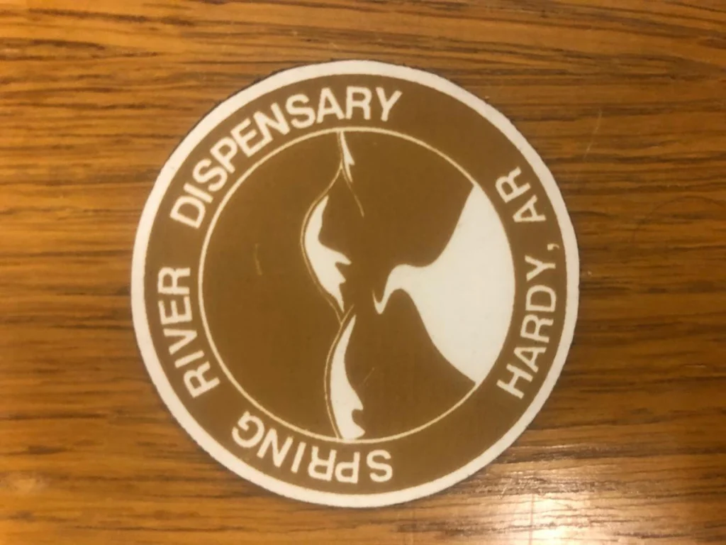 Spring River Dispensary logo on wooden surface.