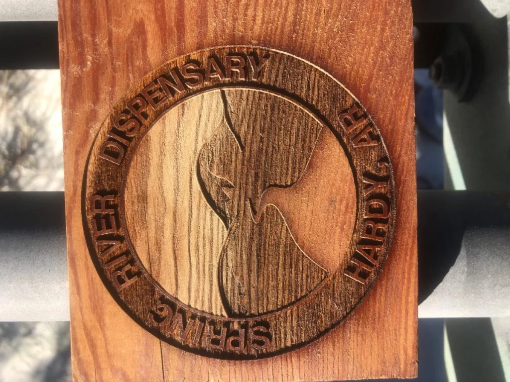 Wood carving of Spring River Dispensary seal.
