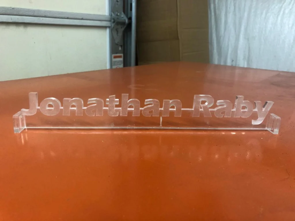 Clear acrylic 3D nameplate on orange table